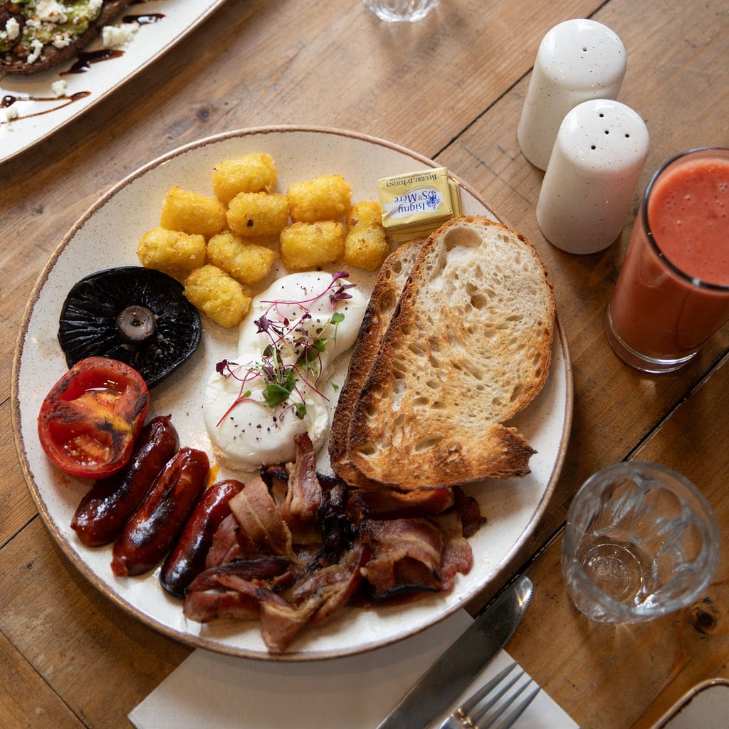 A full breakfast plate from above with juice and water on the table